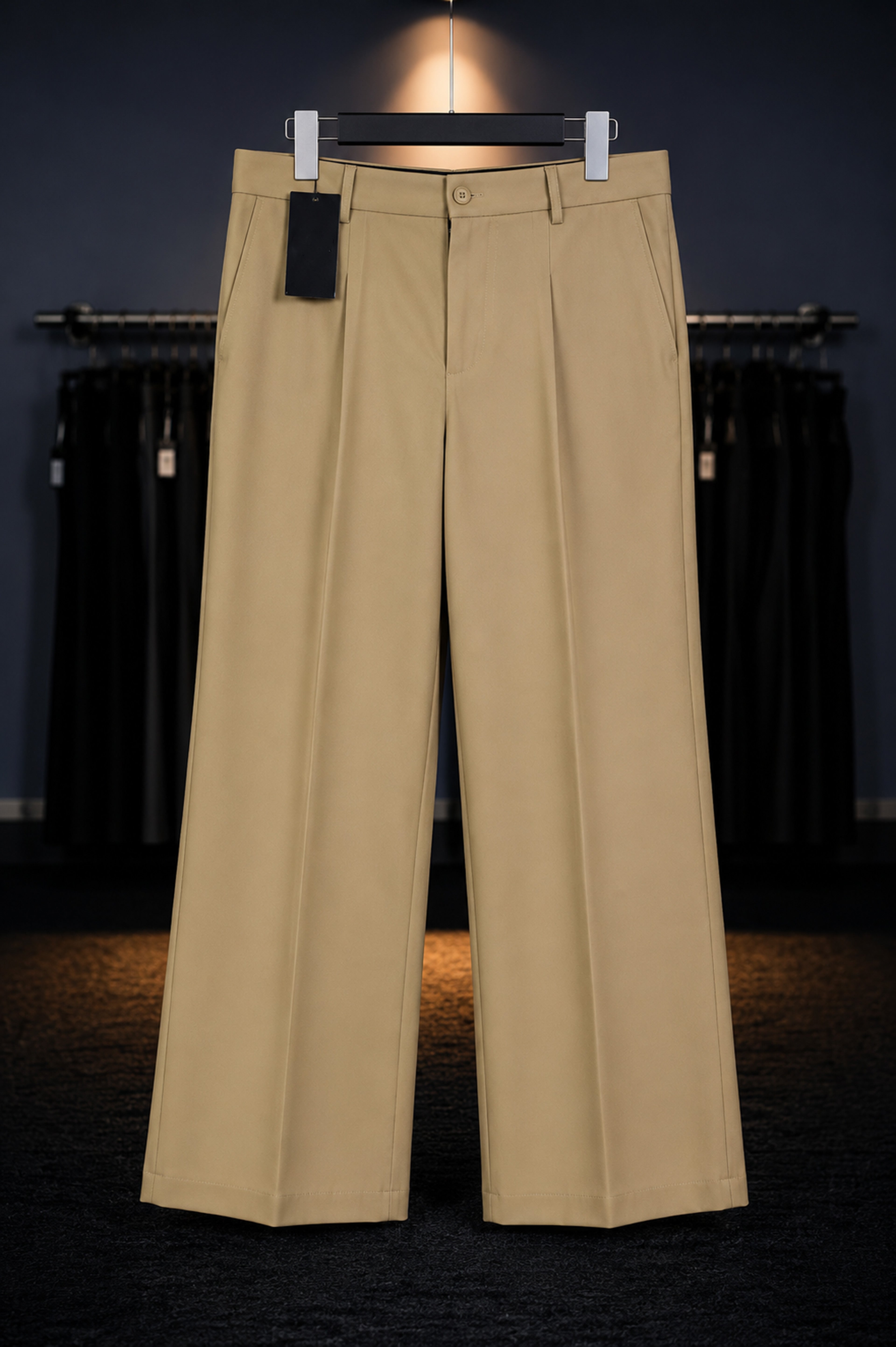 Beige pants on a hanger against a dark background