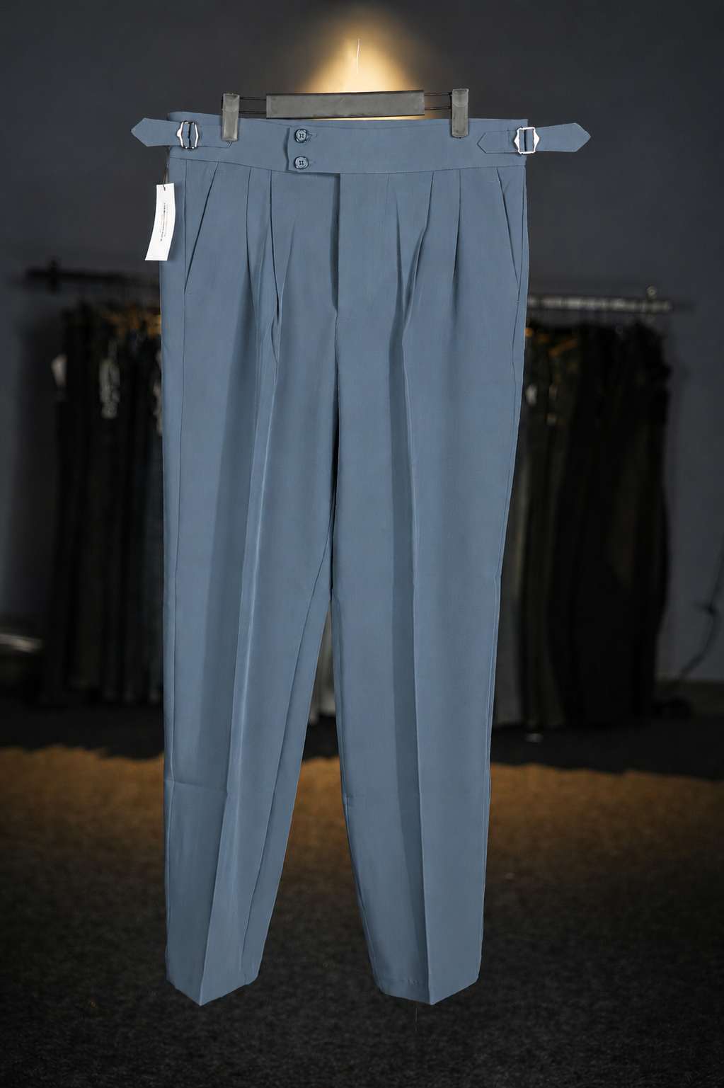 Light blue pants on a hanger against a dark background