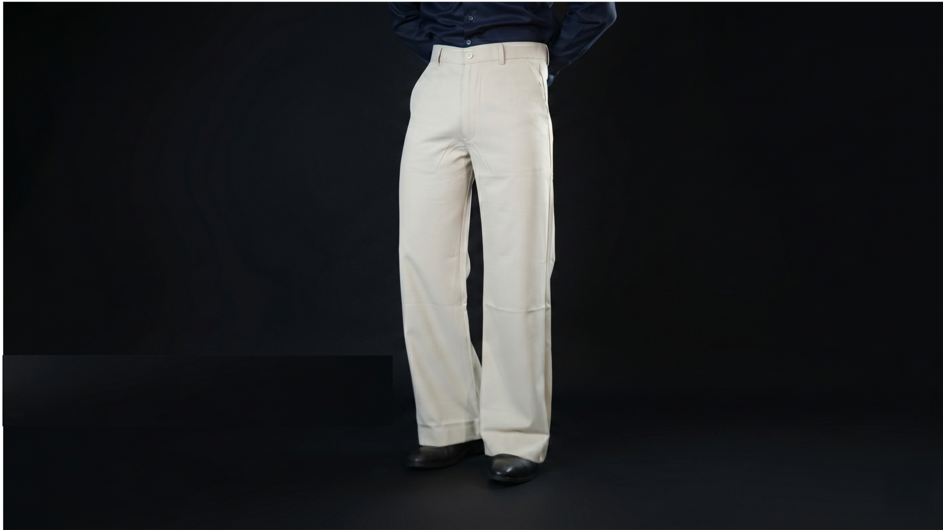 White pants worn by a person on a black background